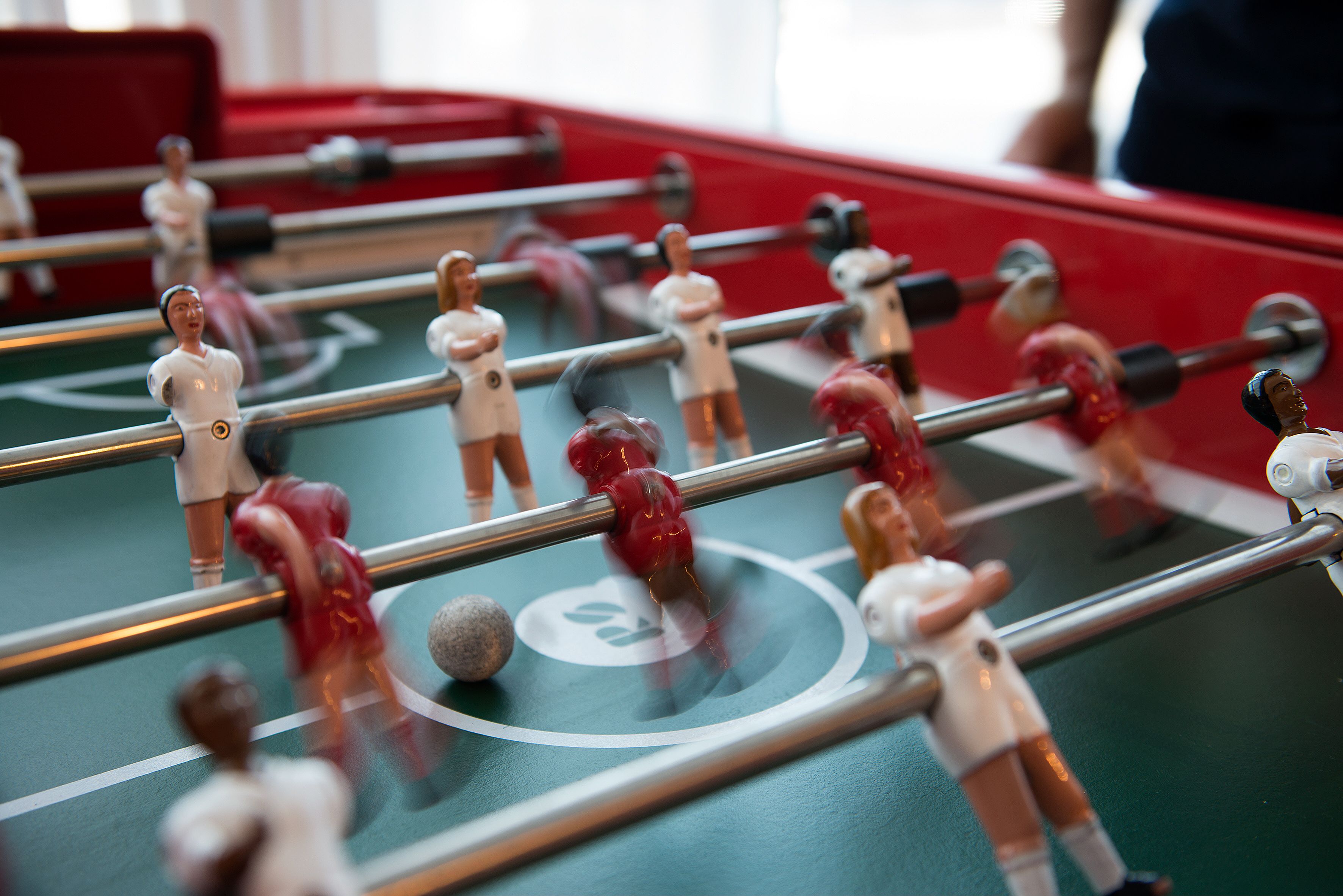 A close-up of a foosball table with miniature figures and rods.