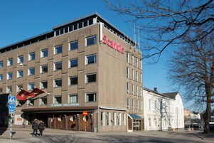 A Scandic hotel with a modern facade, a prominent entrance, and a clear sky.
