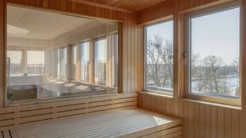 Un interior moderno con ventanas amplias, paneles de madera y un área de descanso.