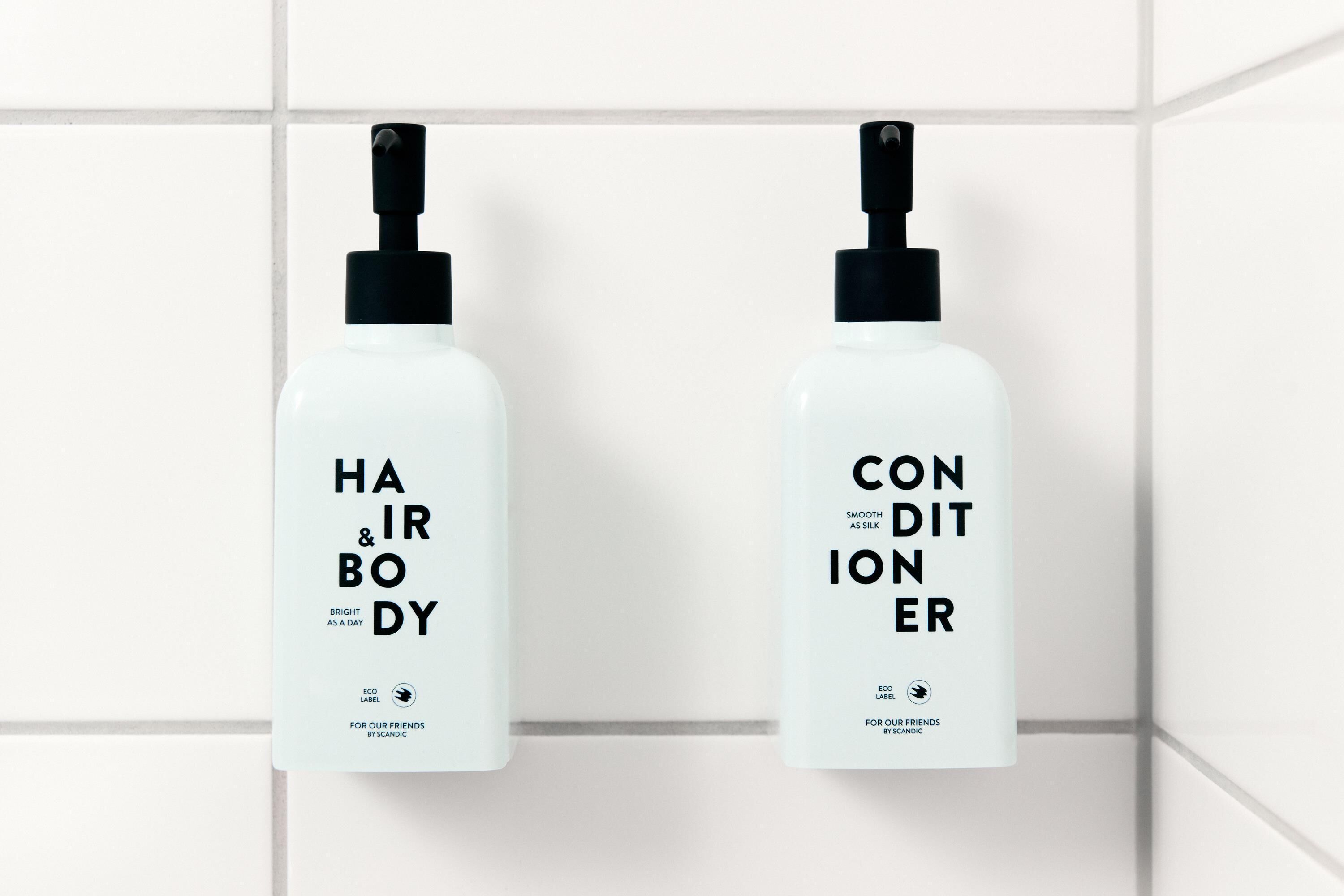 Dos botellas blancas con dosificador negro etiquetadas como 