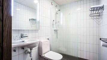A modern bathroom with a white sink, toilet, and glass shower enclosure.