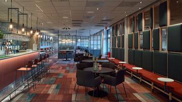 A modern restaurant with a bar area, seating arrangements, and large windows.