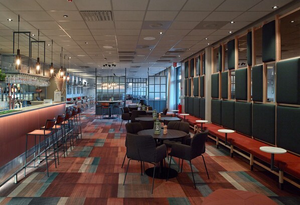 A modern restaurant with a bar area, seating arrangements, and large windows. - Scandic Borlänge (Borlange)