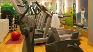 Un gimnasio con cintas de correr, una pelota de ejercicios roja y una máquina FlexDeck.