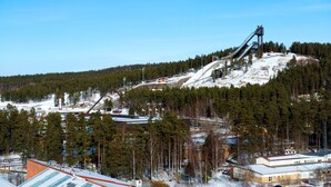 A mountainous area with a ski lift, buildings, and snow-covered ground.