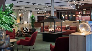 A modern lounge area with seating, a fireplace, and a bar.