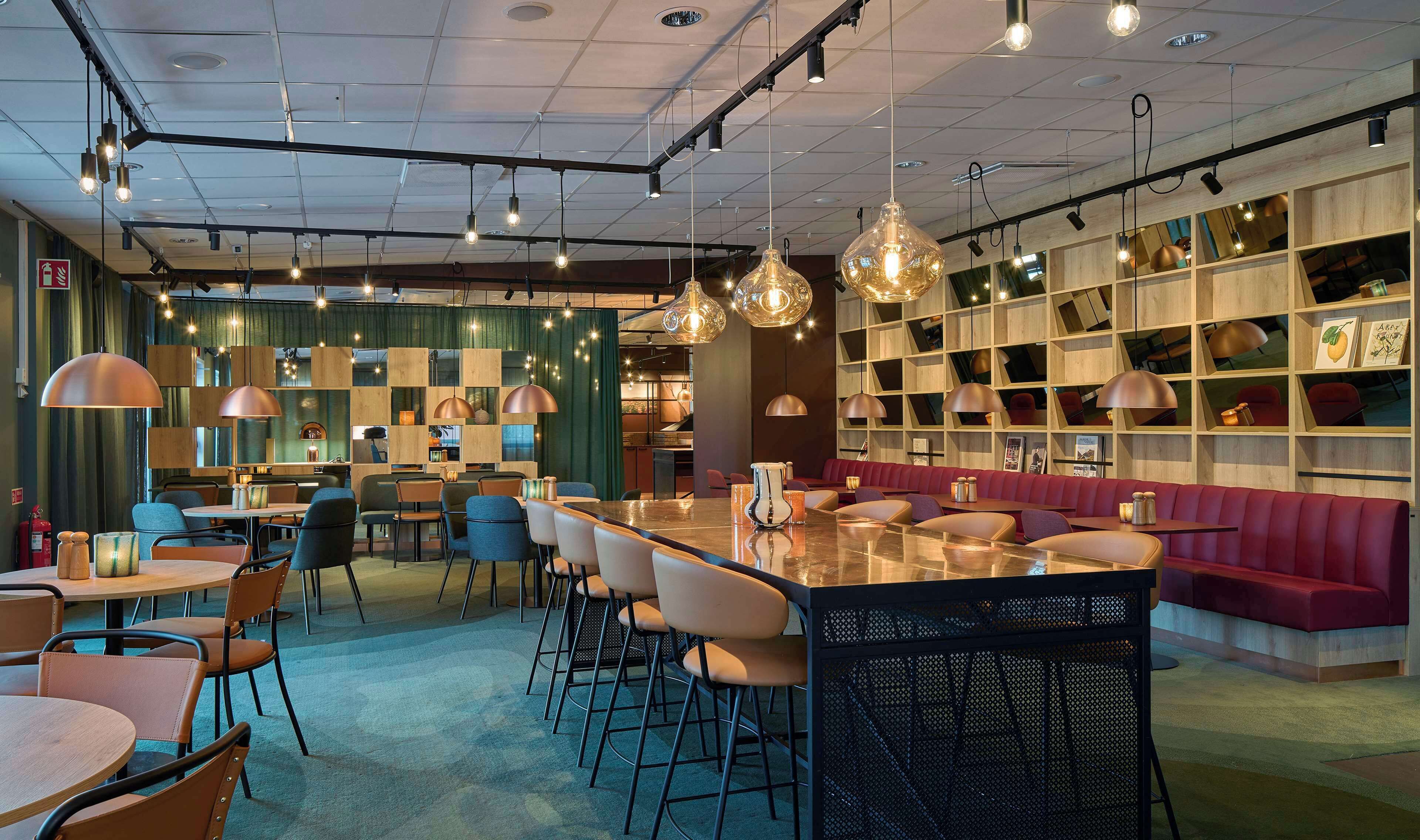 A modern restaurant interior with a bar area, seating, and a bookshelf.