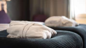 A bed with a dark cover and two pillows.