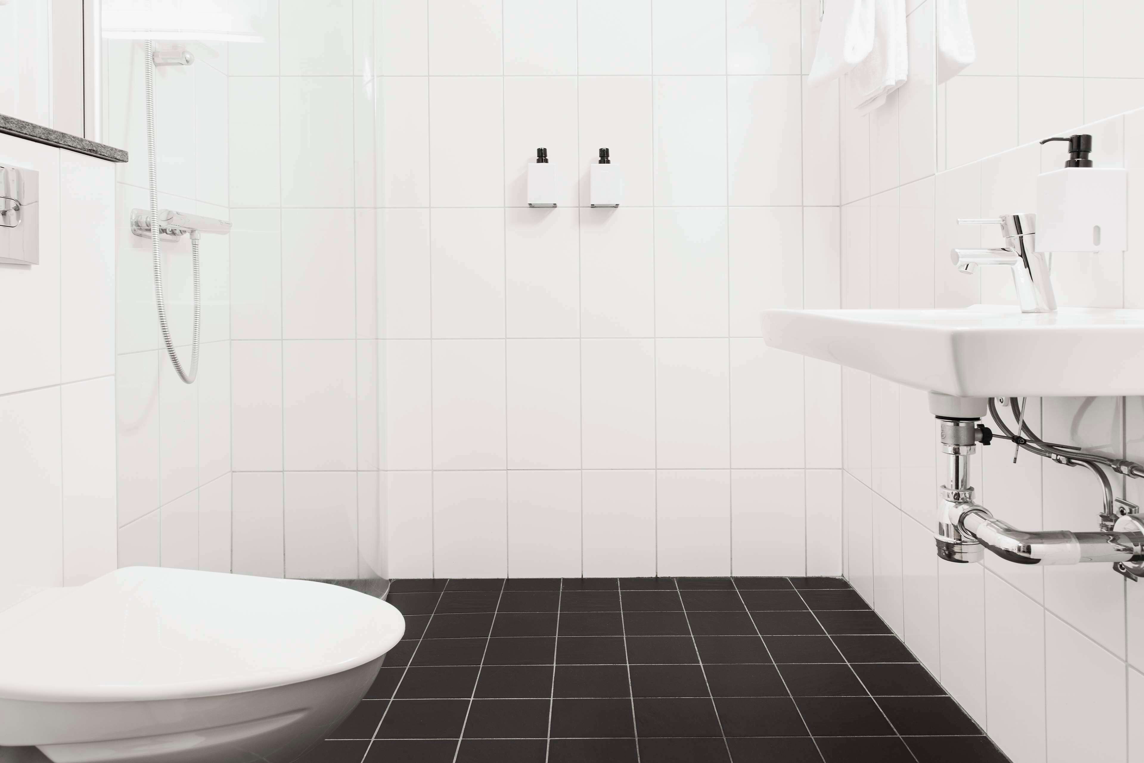 Un baño moderno con inodoro, ducha y lavamanos.