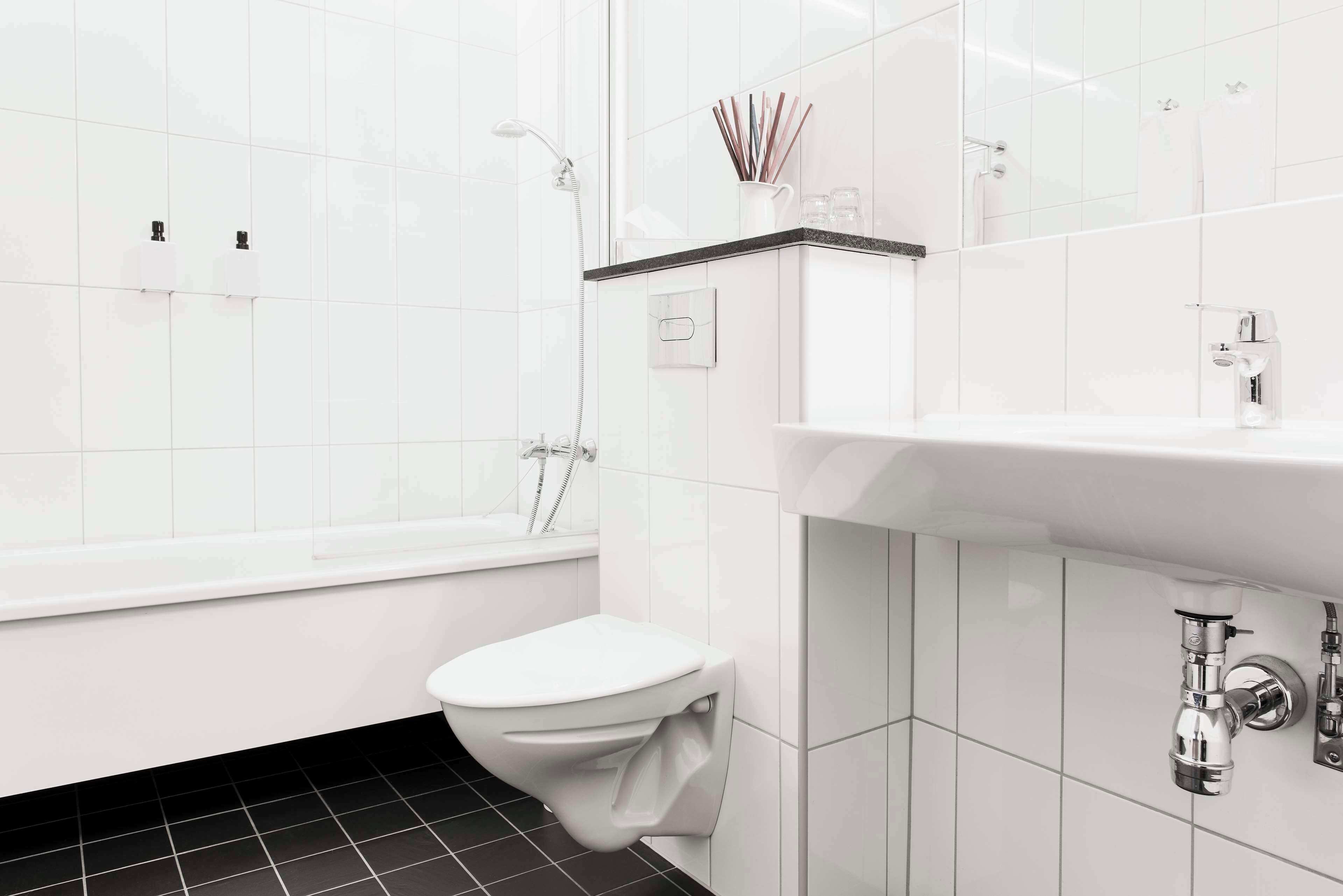 Ein modernes Badezimmer mit Toilette, Badewanne und Waschbecken.