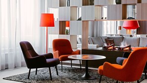 A modern living room with a sofa, chairs, a coffee table, and a fireplace. - Scandic Västerås (Vasteras)