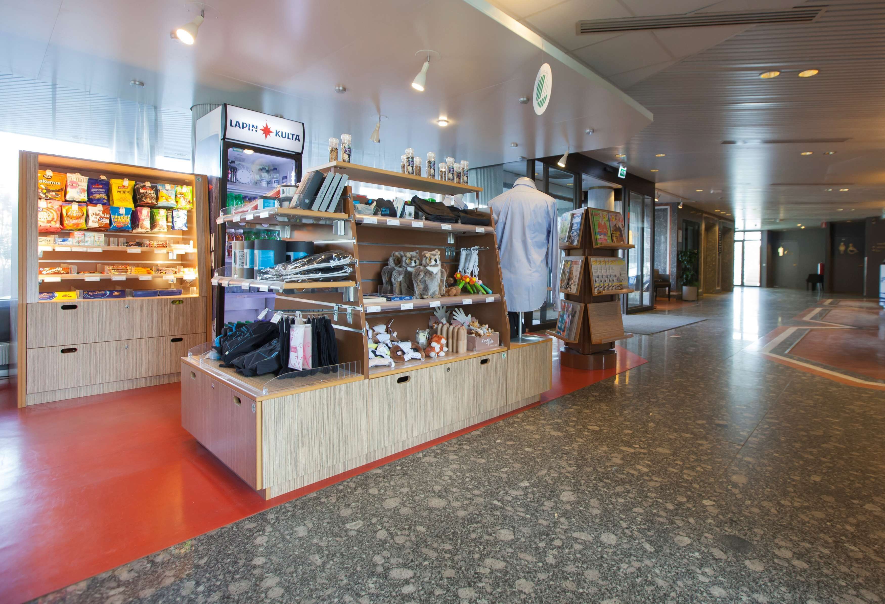 A retail store with shelves stocked with snacks and a mannequin in a white coat.