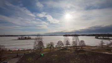 Una vista panorámica de un lago congelado, cielo despejado y colinas distantes.