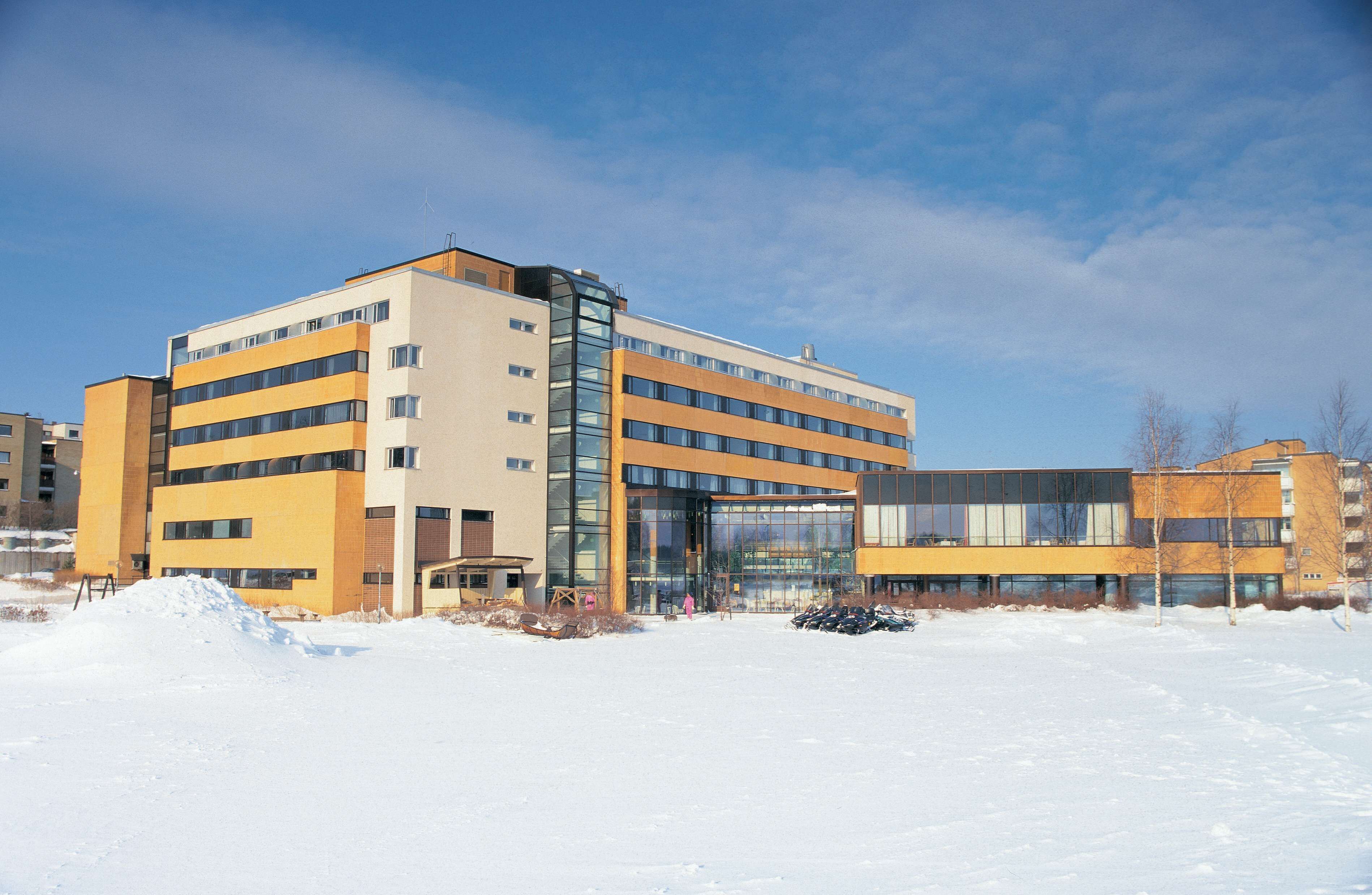 Monikerroksinen hotelli, jossa on moderni muotoilu, suuret ikkunat ja lasijulkisivu.