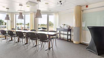 A conference room with a large table, chairs, a projector, and a whiteboard.