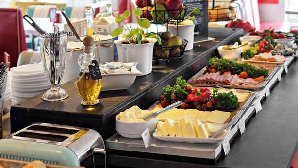 Ein reichhaltiges Buffet mit Käse, Obst und Gemüse.