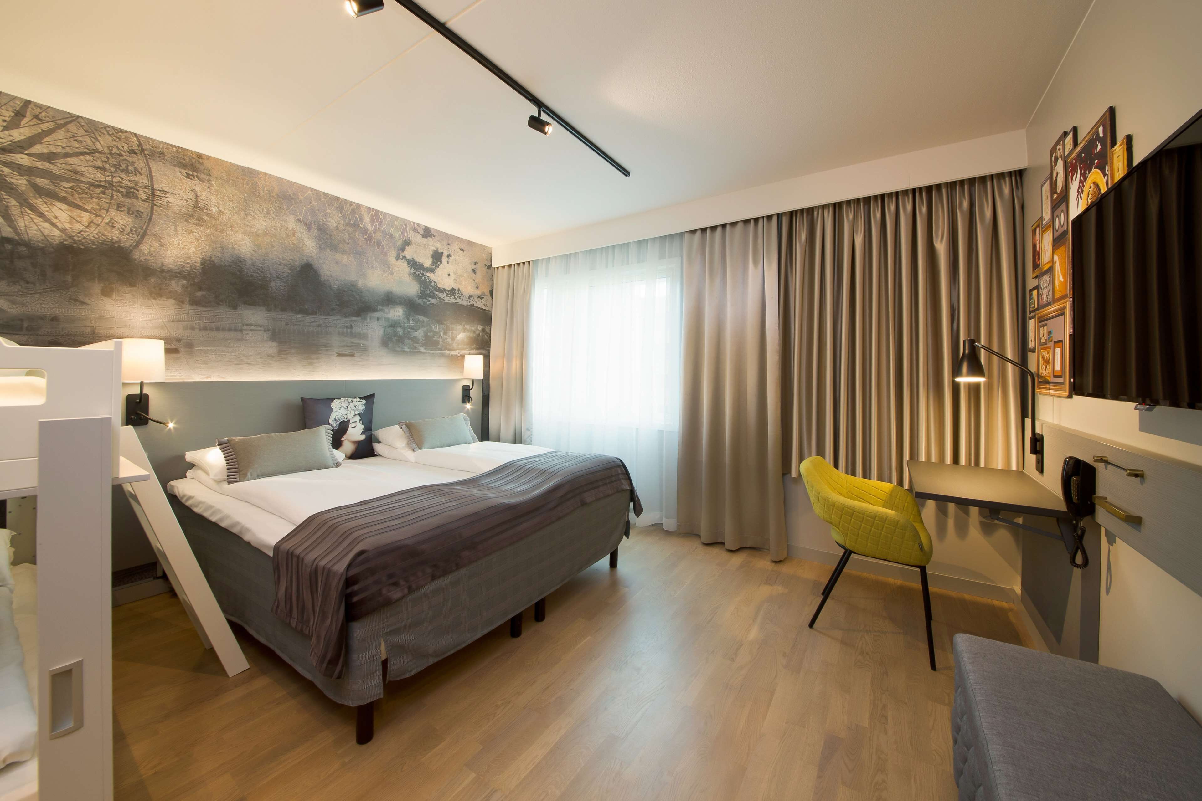 Une chambre d’hôtel moderne avec un grand lit, des lampes de chevet, un bureau et une chaise.