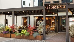 A restaurant named Skadoshage with outdoor seating and a variety of plants in the entrance area. - Scandic Sjølyst (Oslo)
