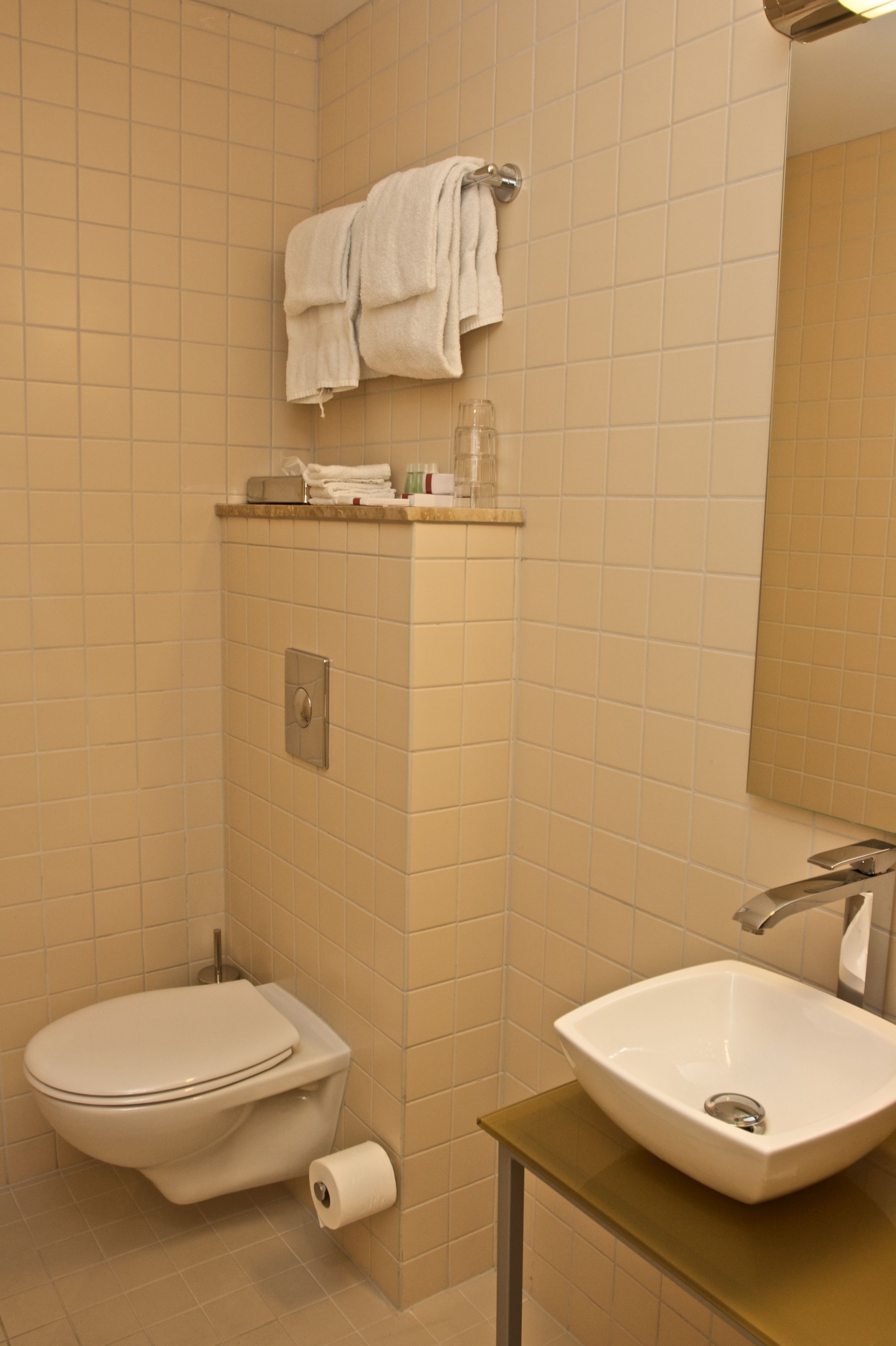 A bathroom with a toilet, sink, and towel rack.