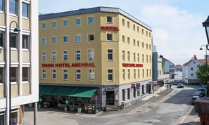 Un edificio de hotel con varias ventanas y un toldo verde.