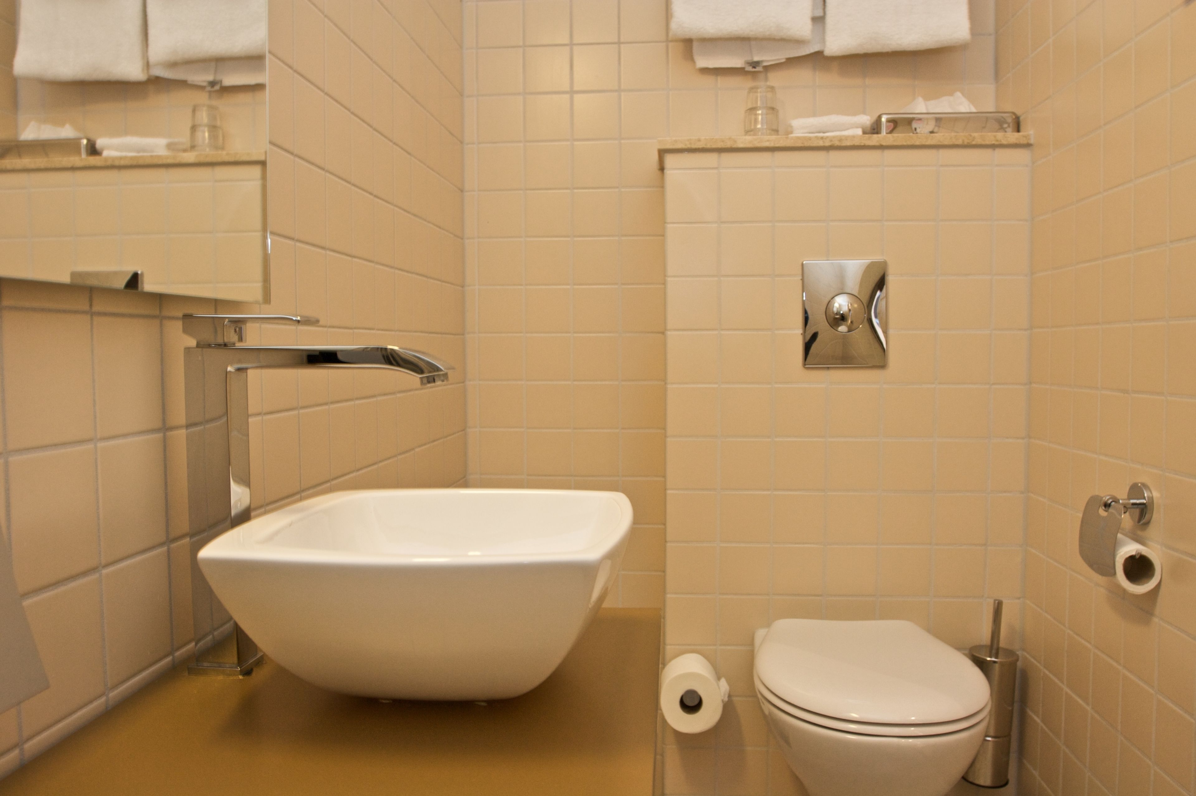 A bathroom with a white sink, toilet, and a towel rack.