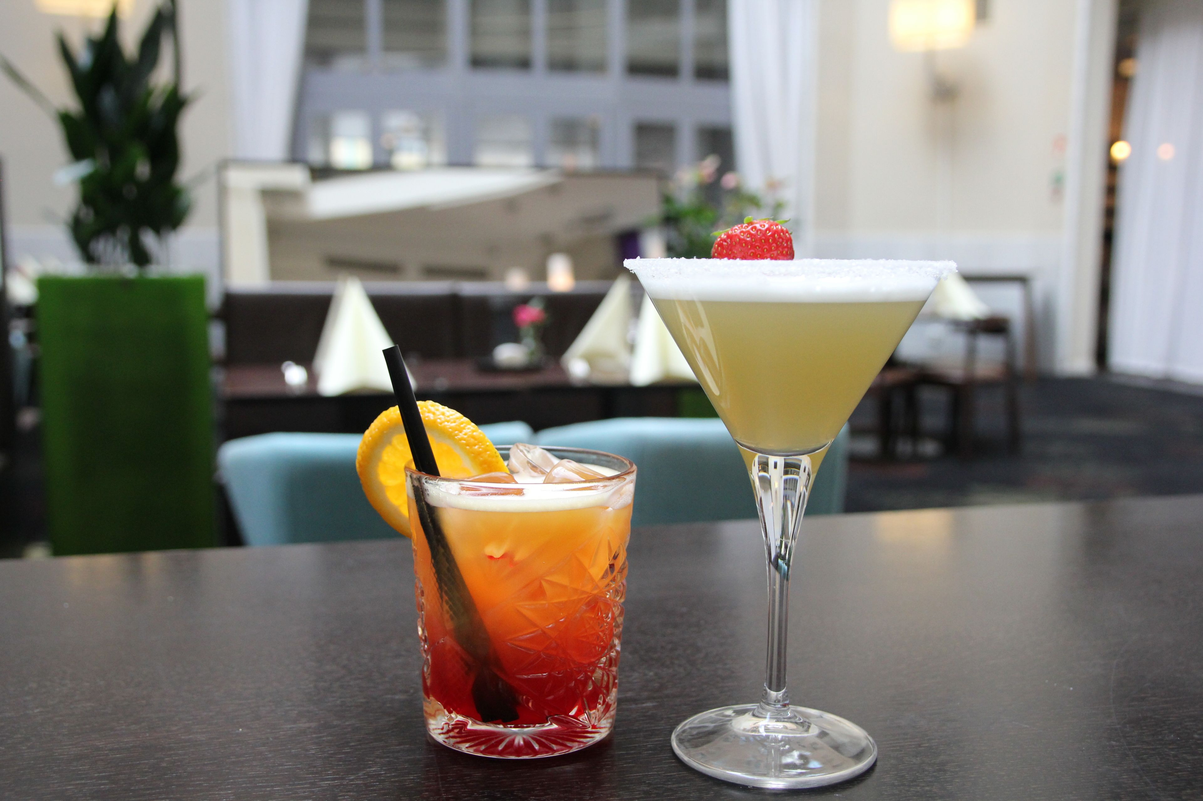Zwei Cocktails auf einem Tisch, im Hintergrund ein Stadtblick.