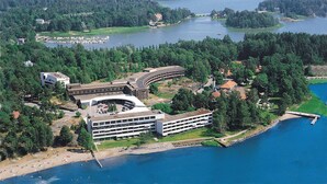 A coastal hotel with a central building, a parking lot, and a beach area. - Hilton Helsinki Kalastajatorppa (Helsinki)