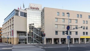 Un bâtiment moderne avec une façade en verre et une enseigne indiquant « Scandic ».