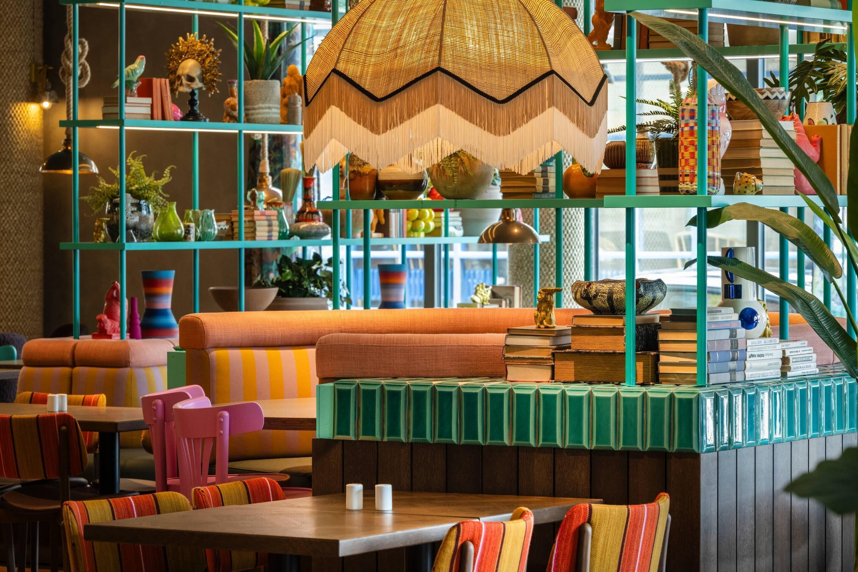 Un rincón acogedor con sillas y un banco coloridos, rodeado de estantes con diversos objetos decorativos.