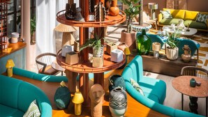 A modern interior with a central wooden column, multiple seating areas, and a variety of decorative items. - Quality Hotel The Reef (Frederikshavn)