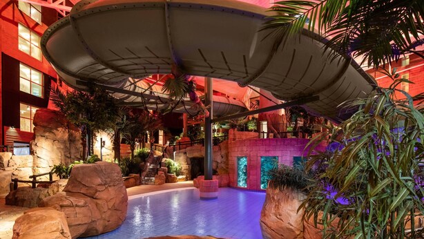 An indoor water feature with a circular pool, surrounded by rock formations and tropical plants. - Quality Hotel The Reef (Frederikshavn)