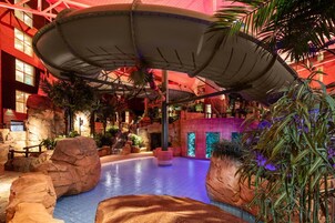 Una piscina techada, una piscina al aire libre, sombrillas