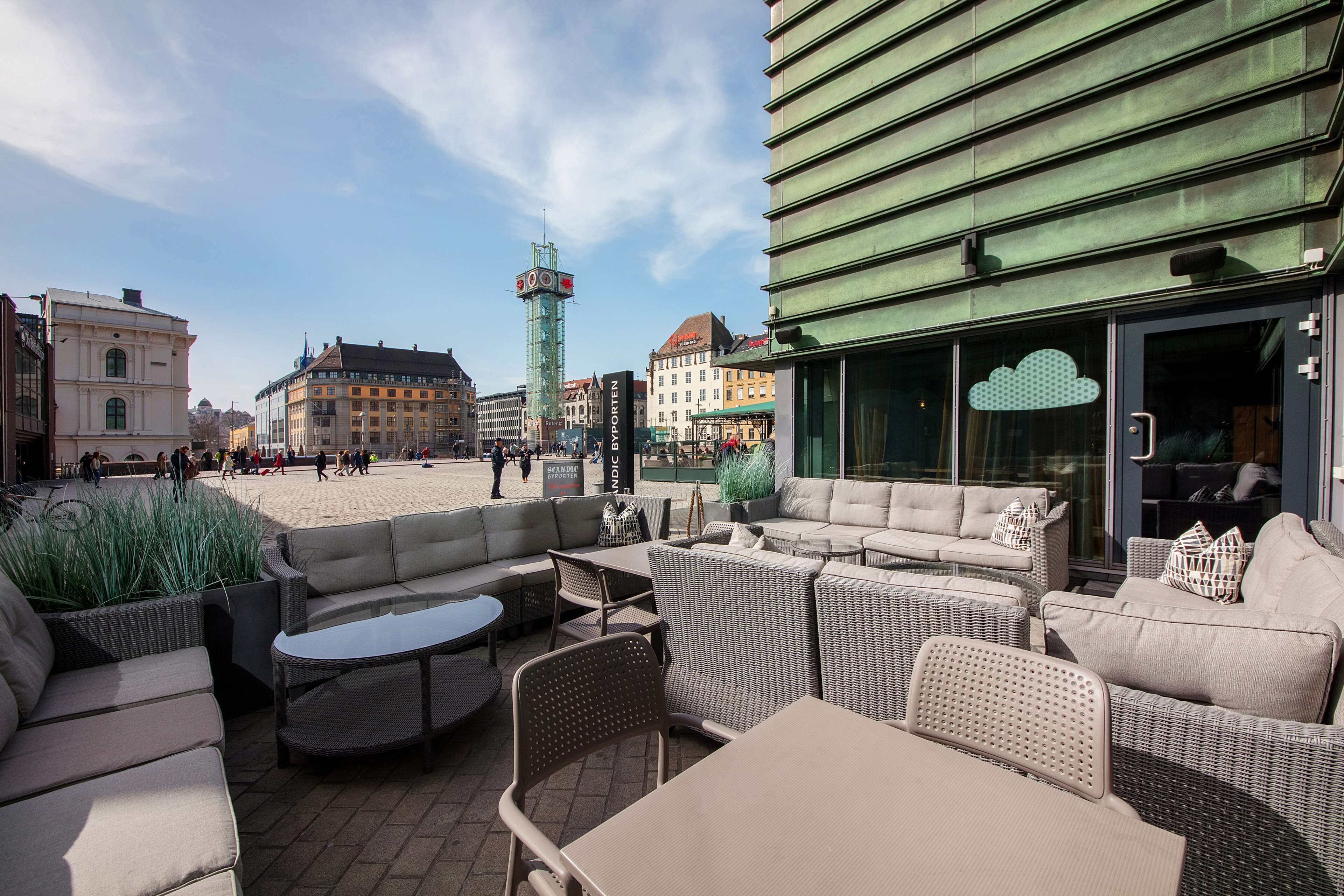 An outdoor seating area with wicker furniture and a view of the cityscape, including a clock tower.