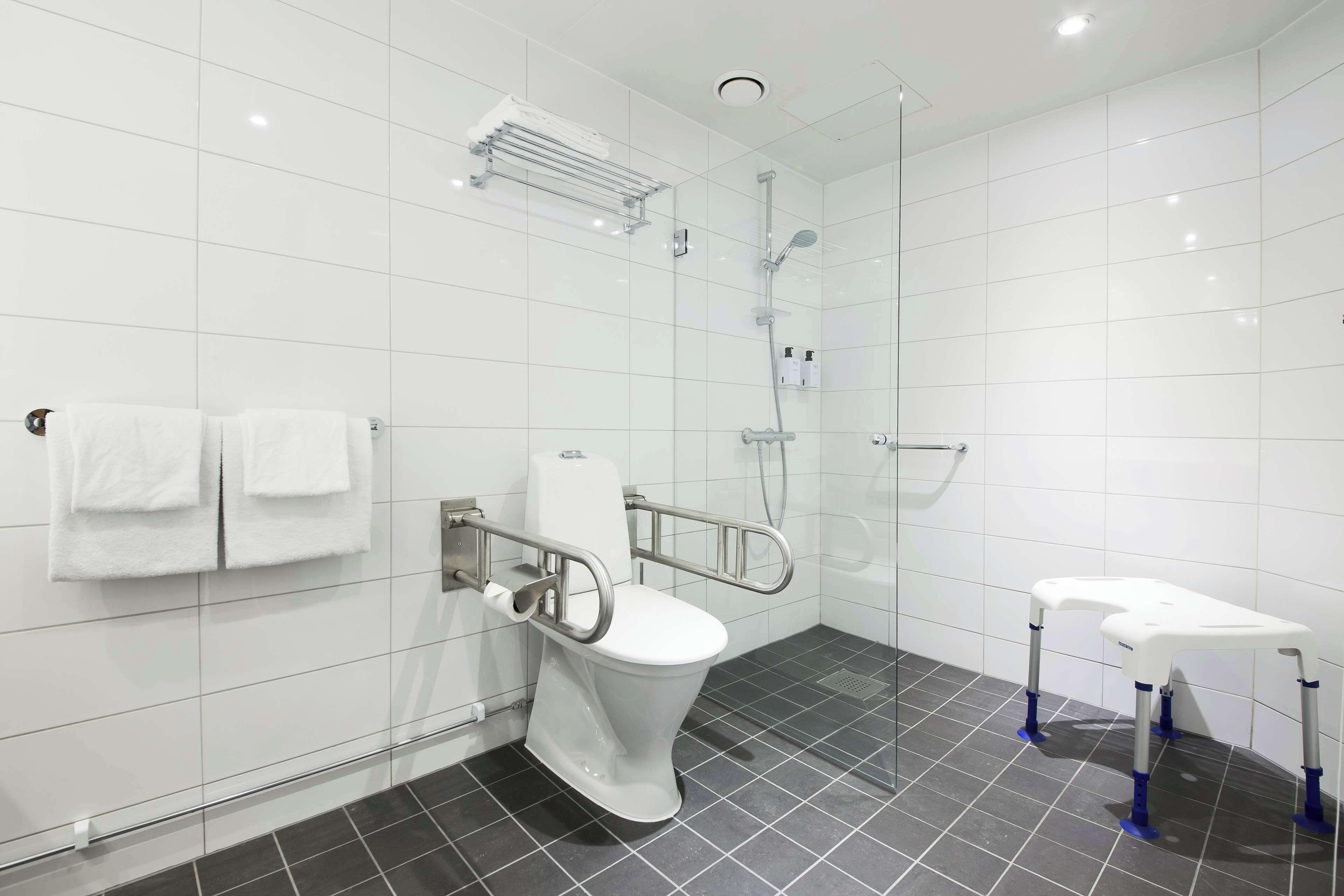 A modern bathroom with a white toilet, a shower, and a sink.