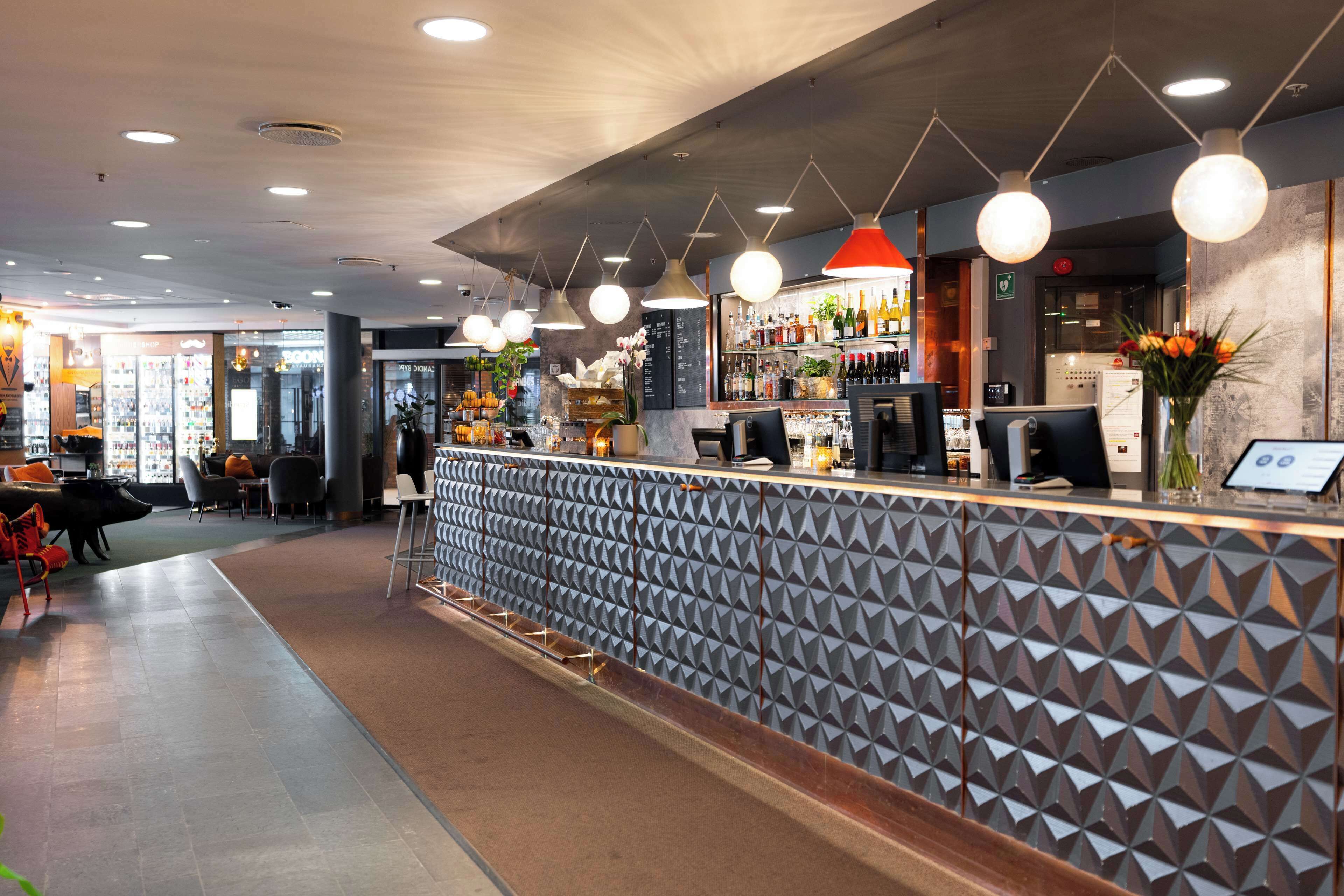 Un moderno bar con mostrador estampado, asientos e iluminación colgante.