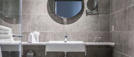Une salle de bain moderne avec un grand lavabo, deux miroirs et des toilettes.