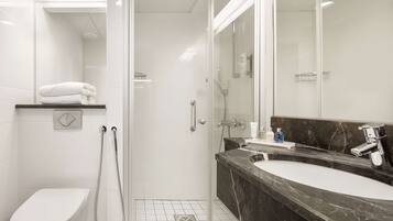 Un baño moderno con inodoro, ducha y lavamanos.