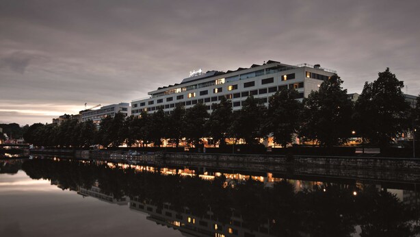 Et moderne hotel med flere etager, med et tydeligt skilt på taget.