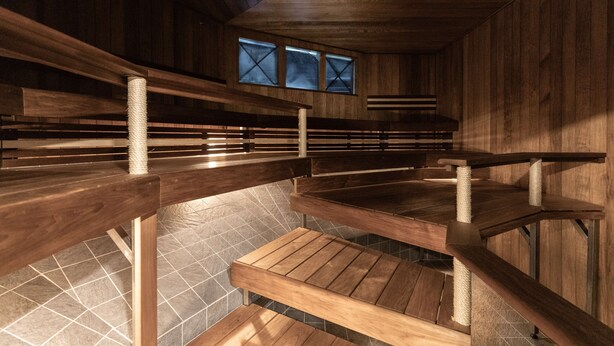 Un interior de madera con asientos escalonados y piso de baldosas.