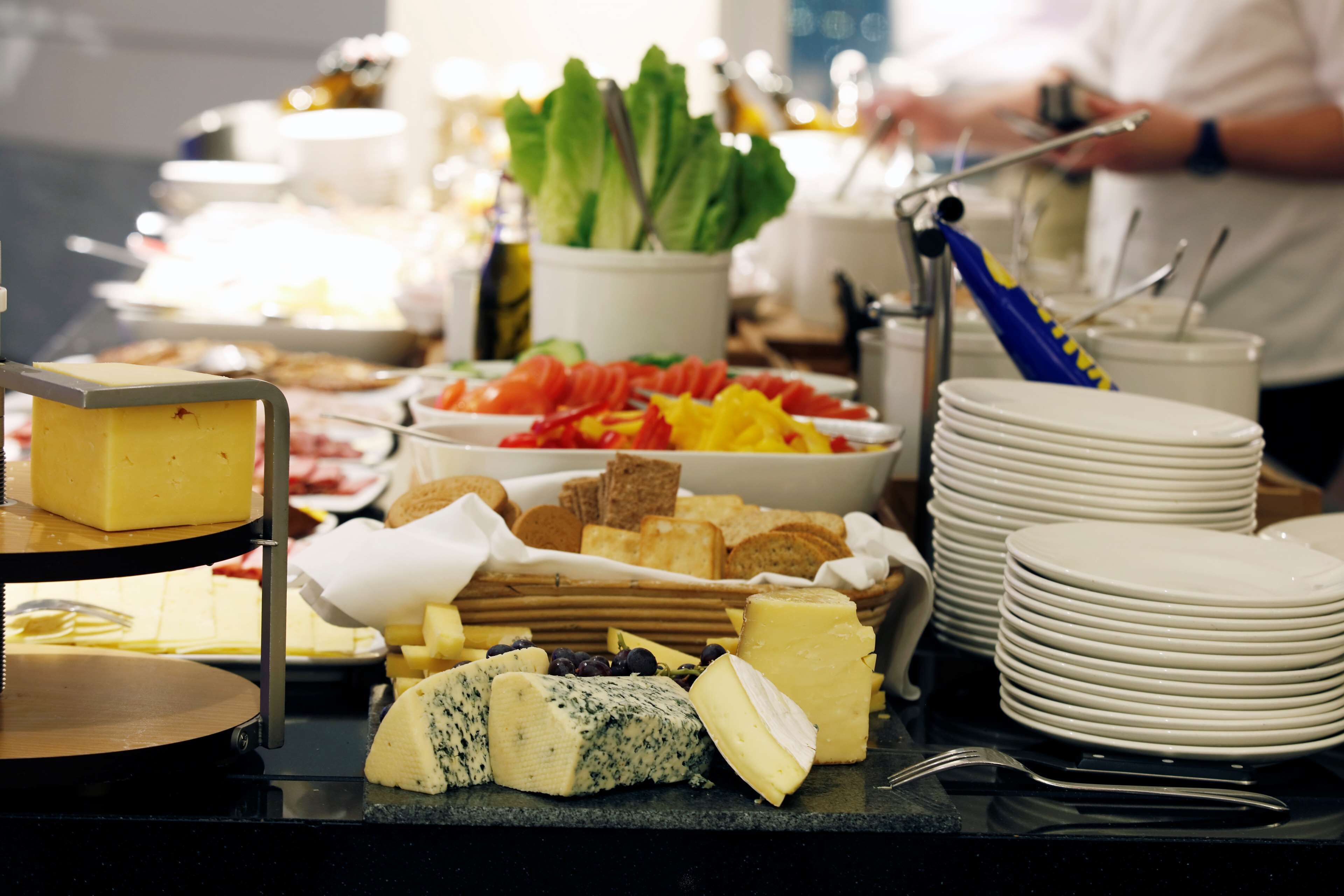 Een buffet met diverse kazen, fruit en brood.