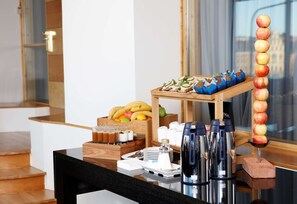 A breakfast buffet setup with fruits, beverages, and utensils on a wooden table. - Hilton Stockholm Slussen (Stockholm)