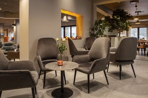 Relax in our stylish lounge area, featuring a round table and comfortable seating for four.