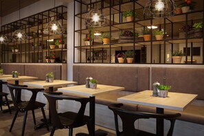 Enjoy a meal in a stylish dining space with tables, chairs, and pendant lights.