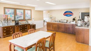 A breakfast area with wooden cabinets, a marble table, and a sign for 'Baymont Breakfast Corner'.