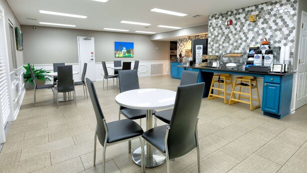 Ein moderner Küchenbereich mit blauer Arbeitsplatte, Edelstahlgeräten und einer gefliesten Spritzschutzwand.