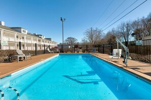 Piscine extérieure en saison, chaises longues