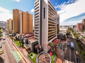 A modern hotel with multiple floors, a rooftop terrace, and a parking area. - Swissotel Quito (Quito)