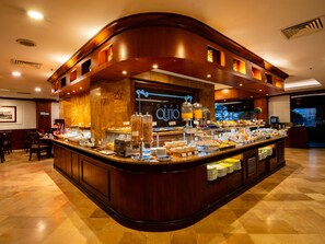 A buffet area with a variety of food items, a coffee station, and a sign that reads "CAFE QUITO". - Swissotel Quito (Quito)