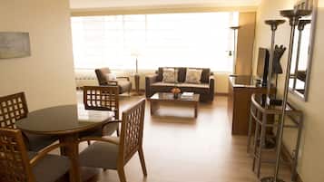 Uma sala de estar moderna com uma mesa de jantar redonda, dois sofás e uma mesa de centro.