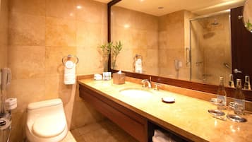 A modern bathroom with a large sink, mirror, and shower.